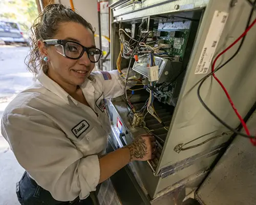 Five Star Services technician Brandi working on an air conditioning repair in Richmond, VA, ensuring efficient and reliable cooling system performance.